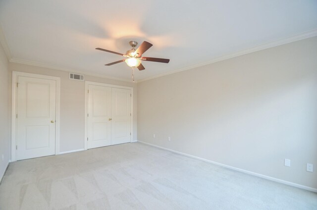 unfurnished bedroom with ornamental molding, light colored carpet, and ceiling fan