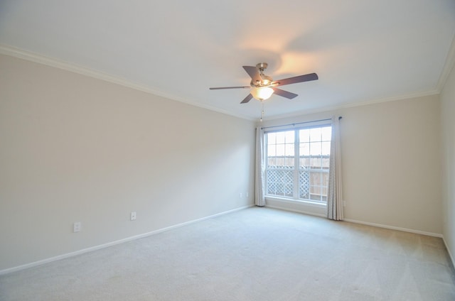 empty room featuring light carpet, ornamental molding, a ceiling fan, and baseboards