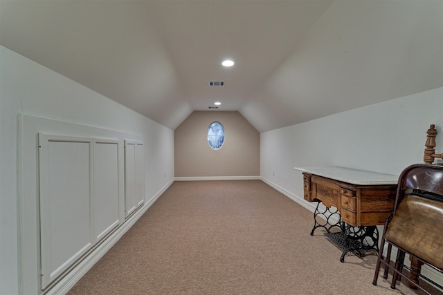 bonus room with light colored carpet and vaulted ceiling