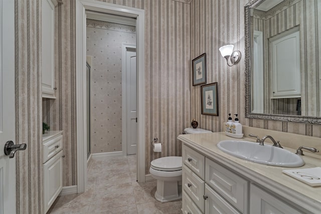 bathroom with tile patterned flooring, a shower with shower door, vanity, and toilet