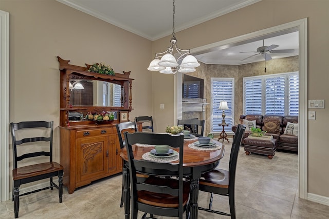 dining area featuring ceiling fan with notable chandelier, crown molding, and light tile patterned floors