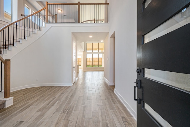 entrance foyer featuring a towering ceiling and hardwood / wood-style floors