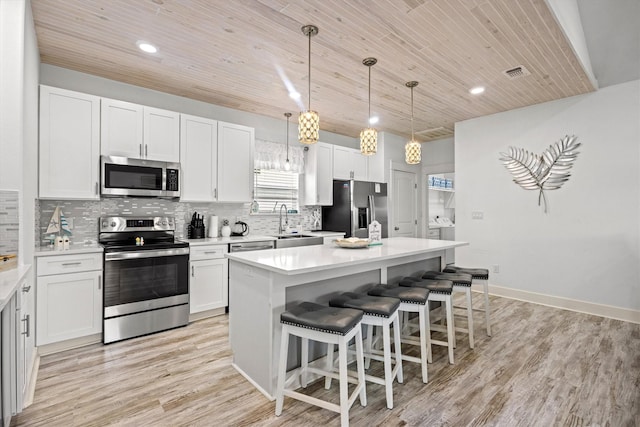 kitchen with wood ceiling, white cabinetry, stainless steel appliances, a center island, and decorative light fixtures