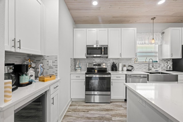 965 Wommack Dr, Crystal Beach, TX 77650 - kitchen with appliances with stainless steel finishes, wine cooler, wooden ceiling, white cabinets, and light wood-style floors