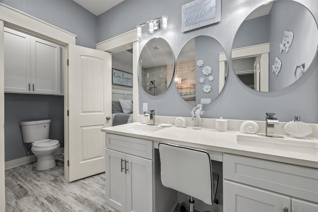 bathroom featuring vanity, hardwood / wood-style floors, a shower, and toilet