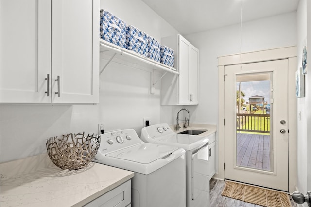 laundry room with cabinets, sink, hardwood / wood-style floors, and washing machine and clothes dryer