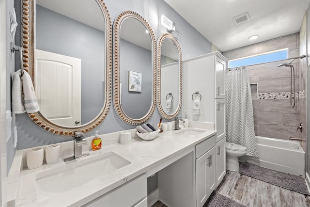 full bathroom with shower / bath combo, hardwood / wood-style floors, vanity, and toilet