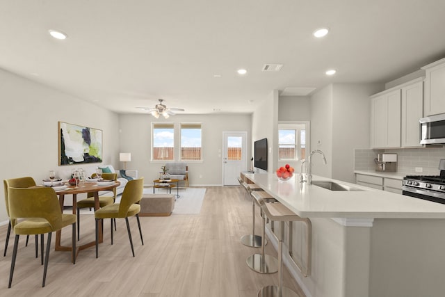 kitchen with white cabinetry, sink, stainless steel appliances, and a wealth of natural light