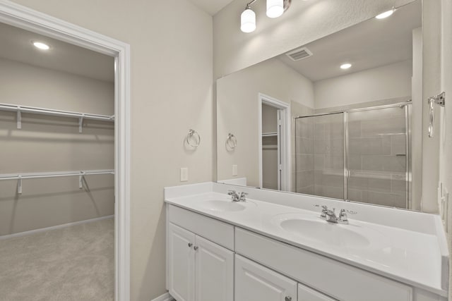 bathroom with a shower with door and vanity