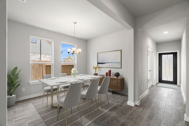 dining area with an inviting chandelier and dark wood-type flooring