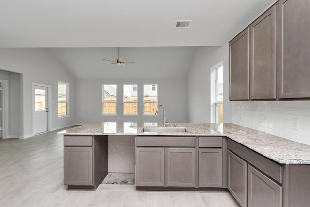19726 Vino Vale Dr, Hockley, TX 77447 - kitchen with a peninsula, a sink, lofted ceiling, tasteful backsplash, and a ceiling fan