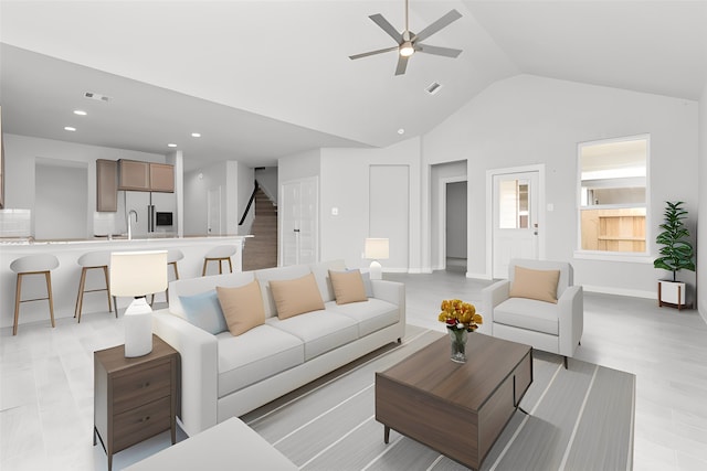 living room featuring ceiling fan, lofted ceiling, light wood-type flooring, and sink