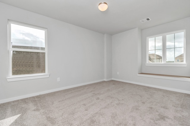 carpeted spare room featuring plenty of natural light