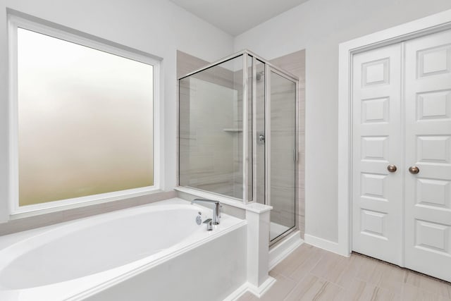 19726 Vino Vale Dr, Hockley, TX 77447 - bathroom featuring a stall shower, a bath, and baseboards