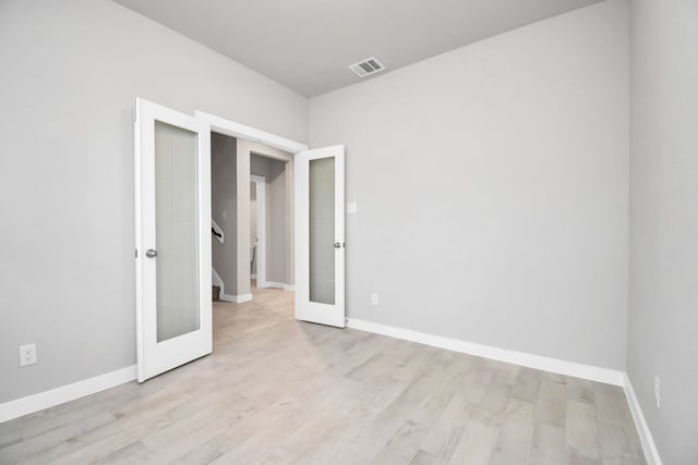 unfurnished bedroom featuring french doors and light hardwood / wood-style flooring