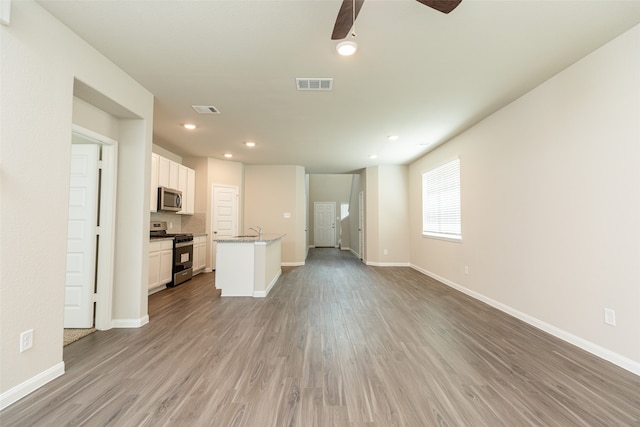 unfurnished living room featuring ceiling fan and light hardwood / wood-style floors