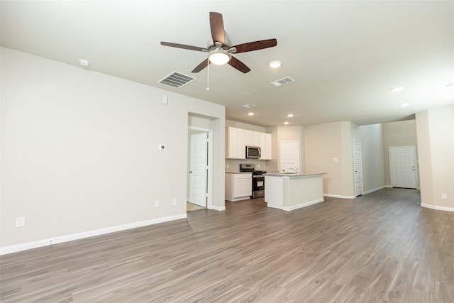 unfurnished living room featuring ceiling fan, light wood-type flooring, and sink