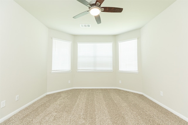 unfurnished room with ceiling fan, carpet, and a healthy amount of sunlight