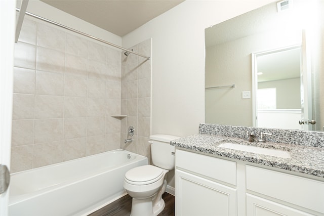 full bathroom with tiled shower / bath combo, hardwood / wood-style flooring, vanity, and toilet