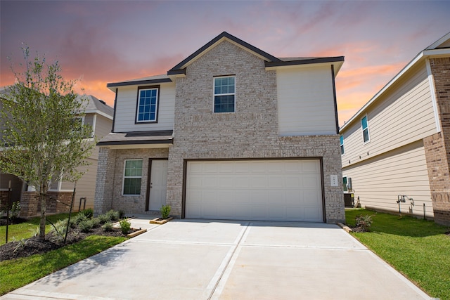 front facade featuring a garage and a yard