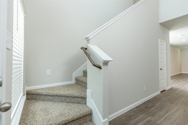 stairs featuring hardwood / wood-style floors