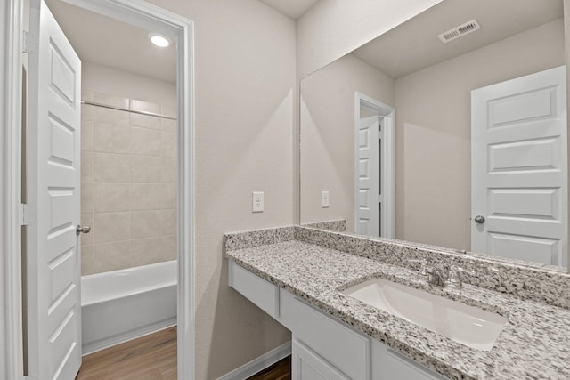 bathroom featuring tiled shower / bath, vanity, and hardwood / wood-style flooring