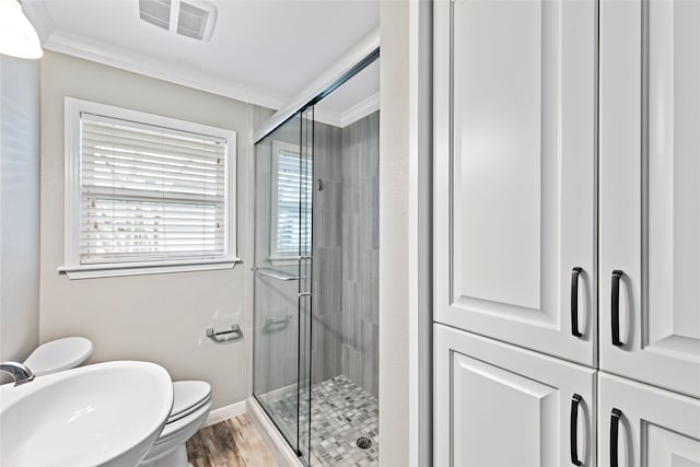 bathroom with walk in shower, ornamental molding, sink, and toilet