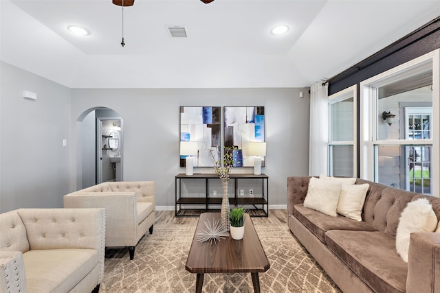 living room featuring vaulted ceiling, ceiling fan, and light hardwood / wood-style flooring