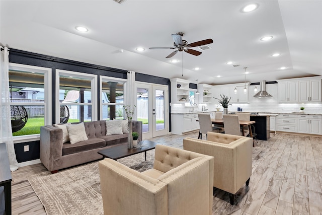 living room featuring light hardwood / wood-style flooring, ceiling fan, and french doors