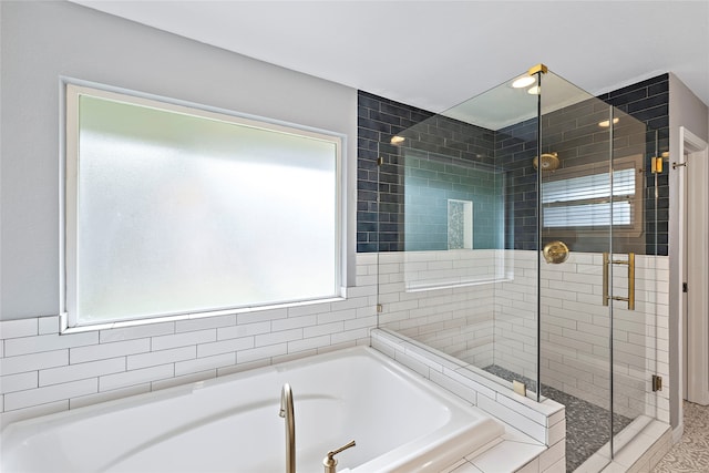 bathroom featuring shower with separate bathtub