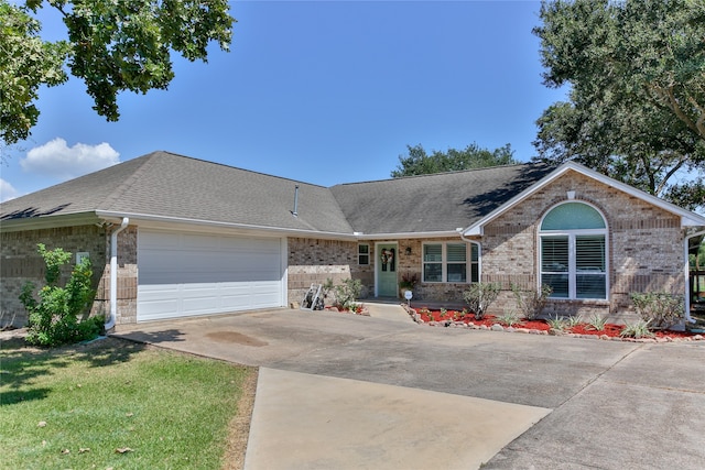 ranch-style house with a garage and a front lawn