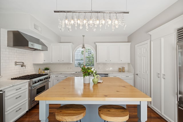 kitchen featuring white cabinets, high end stove, and extractor fan