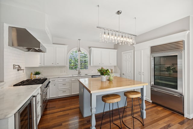 kitchen featuring wine cooler, wall chimney exhaust hood, dark wood-type flooring, and white cabinetry