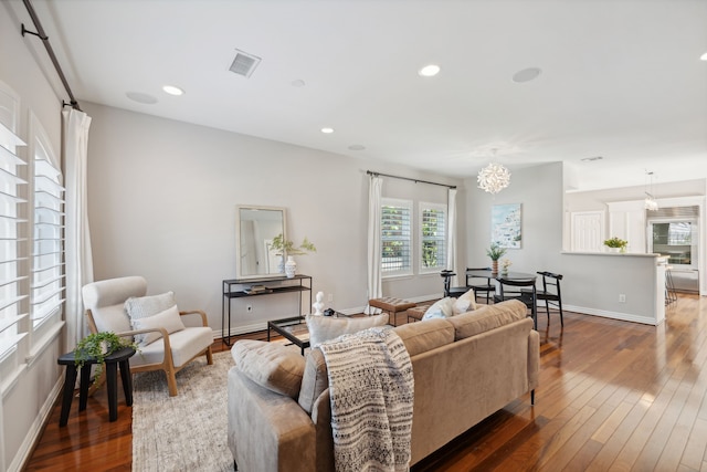 living room featuring a notable chandelier and dark hardwood / wood-style flooring