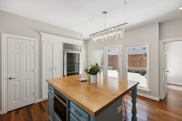 kitchen with dark hardwood / wood-style floors, blue cabinets, a center island, and decorative light fixtures