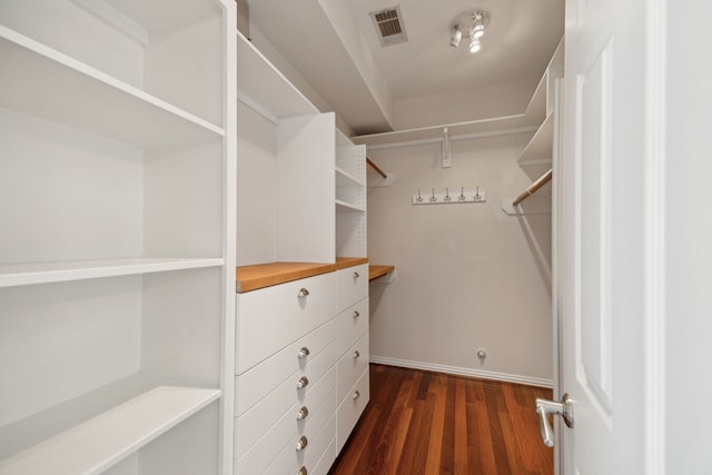 spacious closet with dark hardwood / wood-style flooring