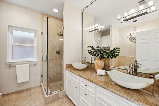 bathroom featuring vanity, a shower with shower door, and tile patterned flooring