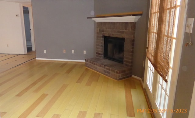 unfurnished living room featuring light hardwood / wood-style flooring, plenty of natural light, and a fireplace