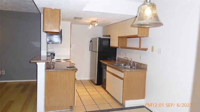 kitchen with dishwasher, a textured ceiling, sink, hanging light fixtures, and stainless steel fridge