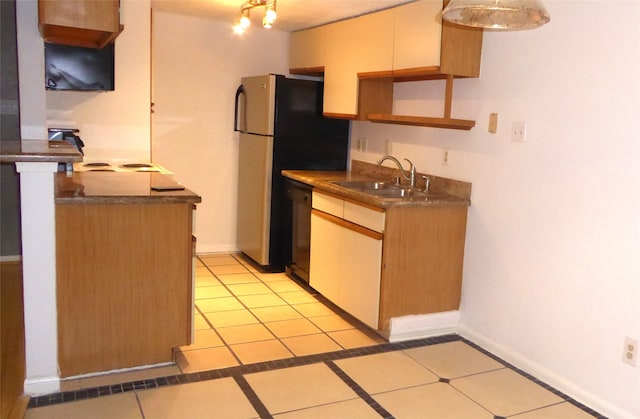 kitchen with dishwasher, stainless steel refrigerator, sink, and light tile patterned floors