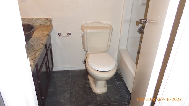 bathroom featuring vanity, a shower, tile patterned flooring, and toilet