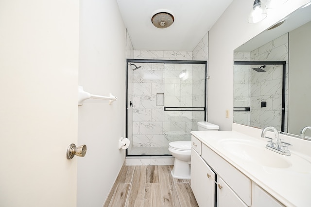 bathroom featuring vanity, toilet, and a shower with shower door