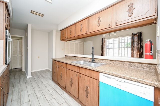 kitchen with white dishwasher, oven, and sink