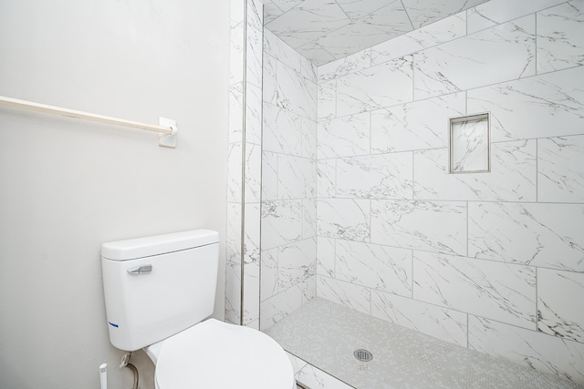 bathroom with toilet and tiled shower