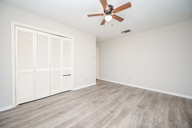 unfurnished bedroom with a closet, light hardwood / wood-style flooring, and ceiling fan