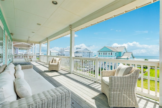 wooden terrace with a water view, a residential view, and an outdoor hangout area