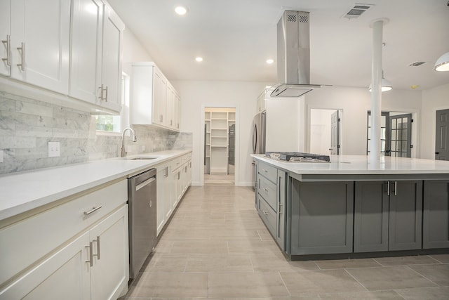 kitchen with white cabinets, sink, a kitchen island, island range hood, and stainless steel appliances