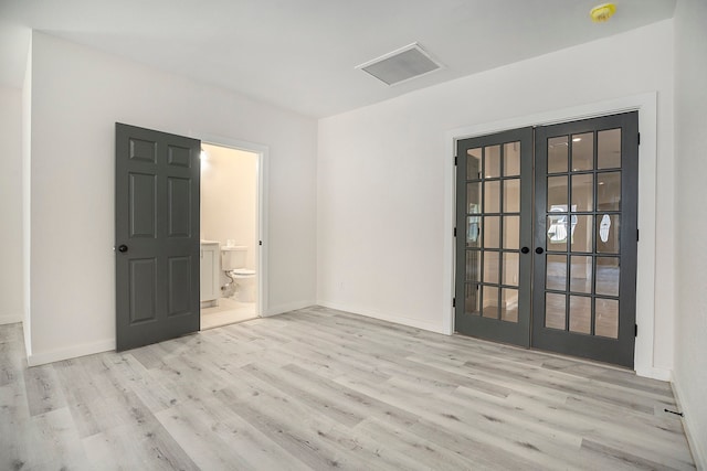 unfurnished bedroom with french doors, light hardwood / wood-style flooring, and connected bathroom