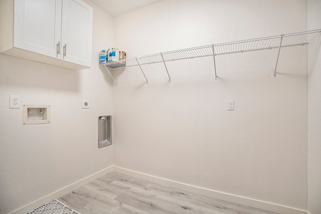 washroom with cabinets, hookup for an electric dryer, light hardwood / wood-style floors, and washer hookup