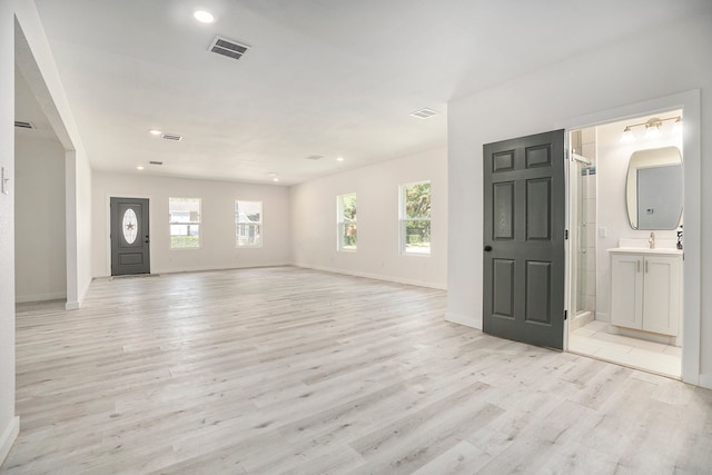 entryway featuring light wood-type flooring, plenty of natural light, and sink